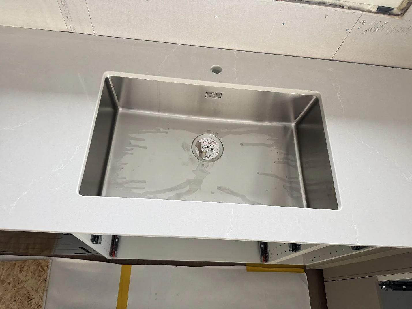 Detalj av diskho i köksbänkskiva av polerad Silestone Desert Silver, komposit, i Sandared.