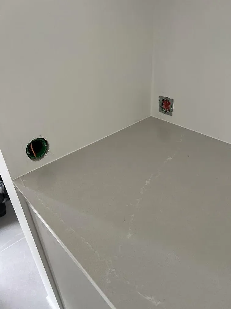 Detaljbild av ljus Silestone Desert Silver bänkskiva med polerad yta, ådring och vägguttag i Skanör.