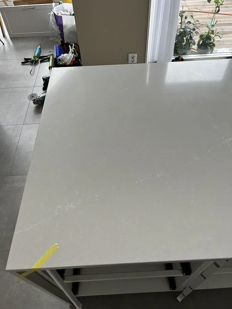 Detaljbild av den polerade Silestone Desert Silver-ytan på en installerad köksö i ett ljust kök i Svedala.