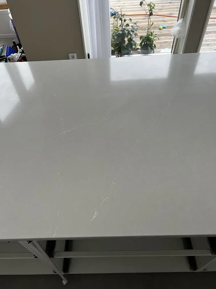 Ytnära bild av ljus Silestone Desert Silver komposit med diskret ådring på köksbänkskiva i Svedala.
