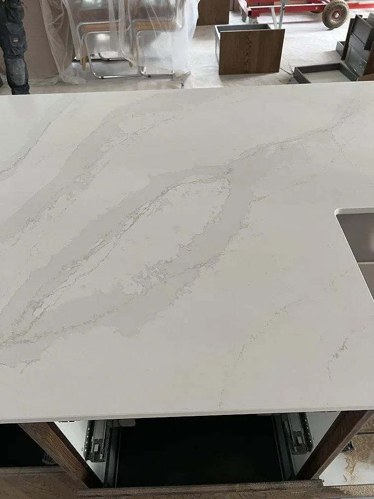 Polerad kompositbänkskiva i Silestone Eternal Calacatta Gold med utskärning för rostfri diskho och synlig ådring i Åhus.