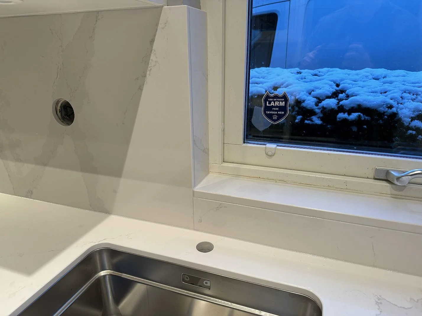 Köksbänkskiva i polerad Silestone Eternal Calacatta Gold med rostfri diskho, fönsterbänk och matchande stänkskydd i Bunkeflostrand.