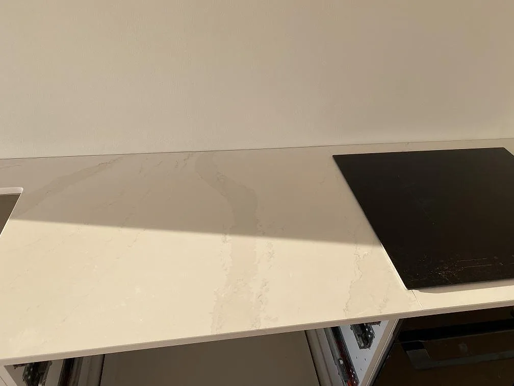 Köksbänkskiva i Silestone Eternal Calacatta Gold i Halmstad med induktionshäll och polerad vit yta med Calacatta-ådring.