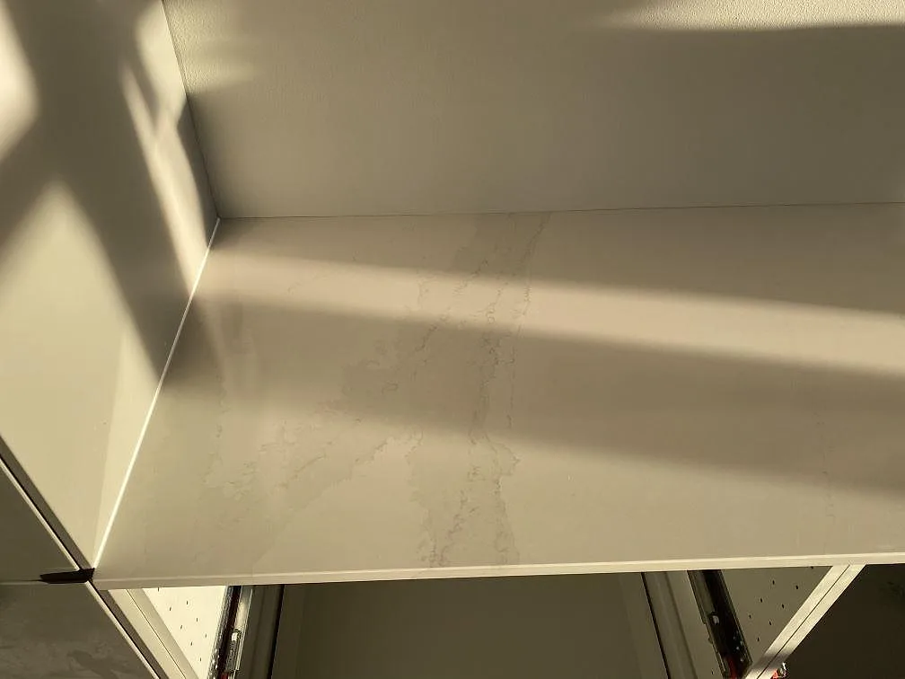 Polerad köksbänkskiva i vit Silestone Eternal Calacatta Gold med mjuk gråådring sedd ovanifrån i ett kök i Halmstad.
