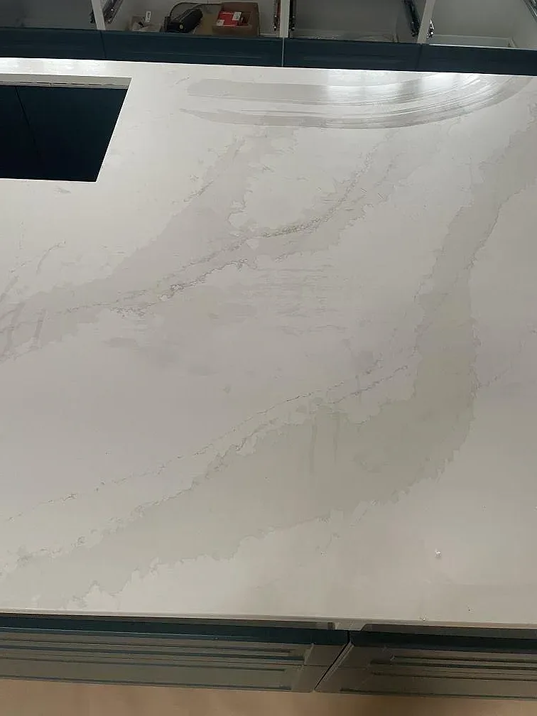 Närbild på den polerade kompositskivan Silestone Eternal Calacatta Gold med kraftig Calacatta-ådring på köksön i Hornbæk.