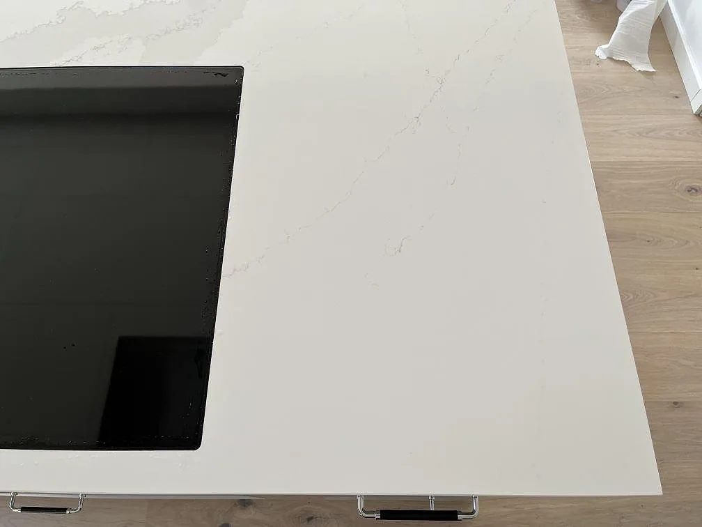 Köksö i polerad Silestone Eternal Calacatta Gold med infälld induktionshäll, sedd uppifrån, i Löddeköpinge.