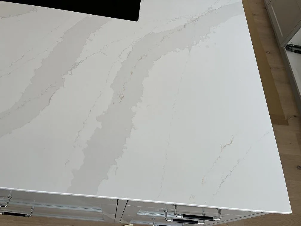 Närbild på den grå och guldfärgade Calacattaådringen i en köksö av polerad Silestone Eternal Calacatta Gold i Löddeköpinge.