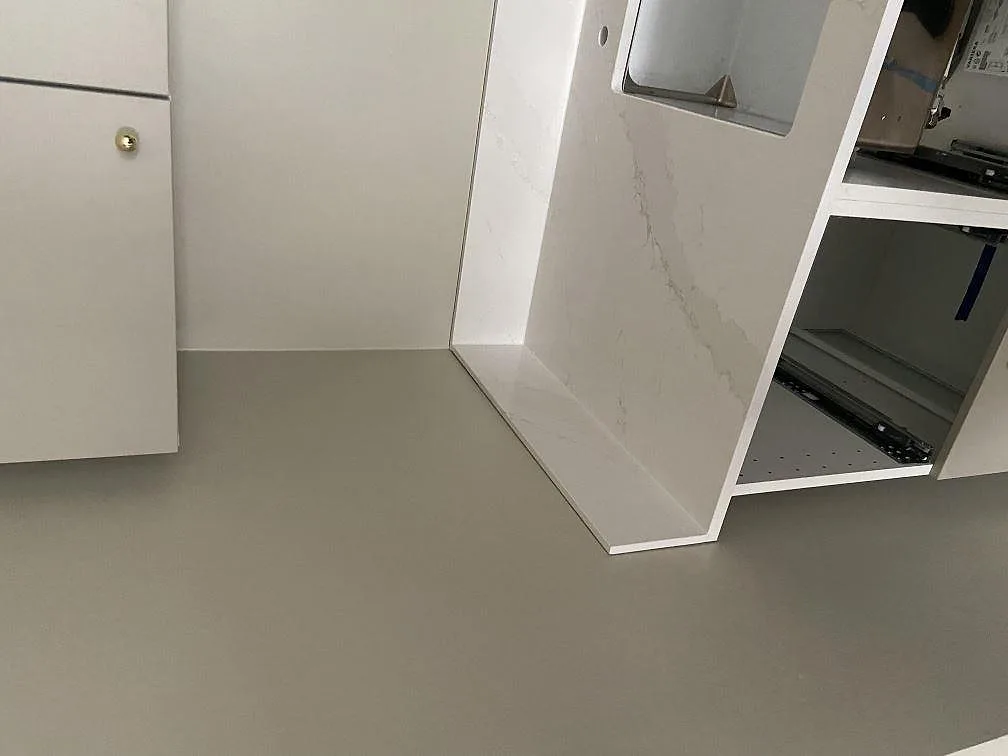Köksö i Silestone Eternal Calacatta Gold med hel stensida i waterfall ner mot golvet i ett kök i Malmö.