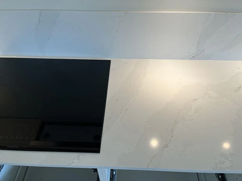 Närbild på den polerade ytan i Silestone Eternal Calacatta Gold med tydlig Calacatta-ådring på köksbänkskivan i Malmö.