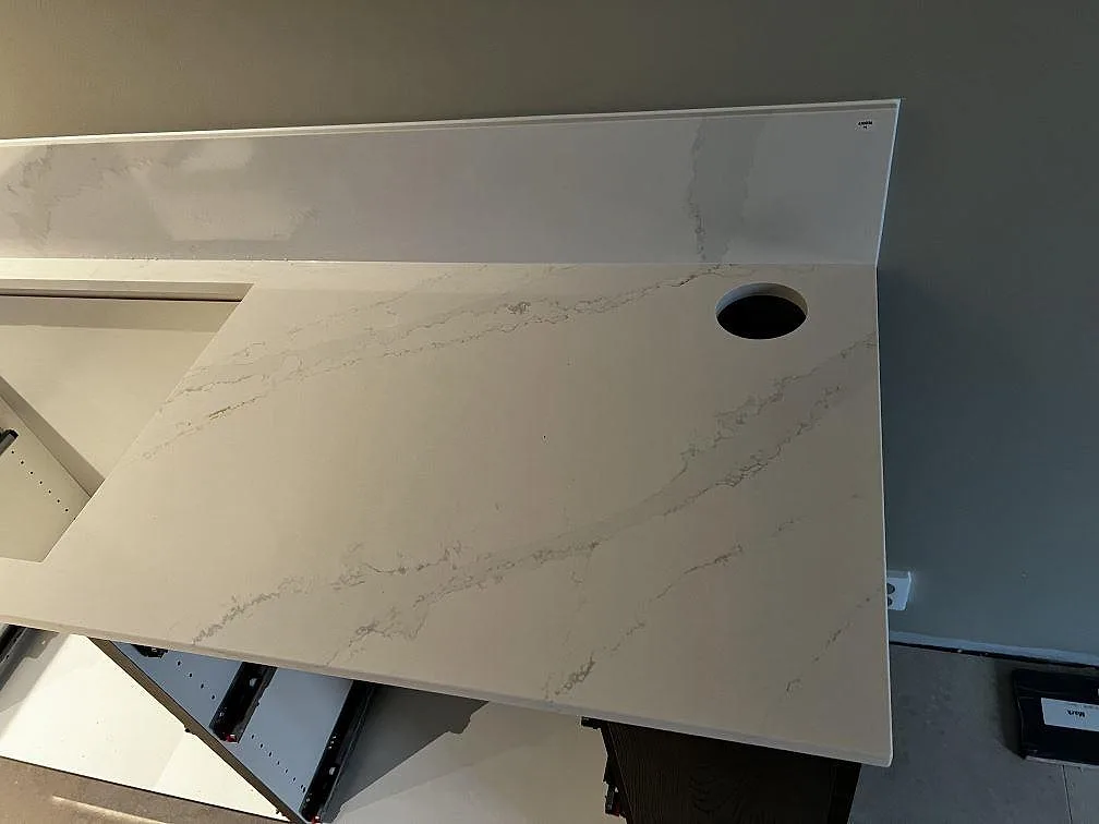 Polerad köksbänkskiva i Silestone Eternal Calacatta Gold med stänkskydd och rund håltagning i ett kök i Malmö.