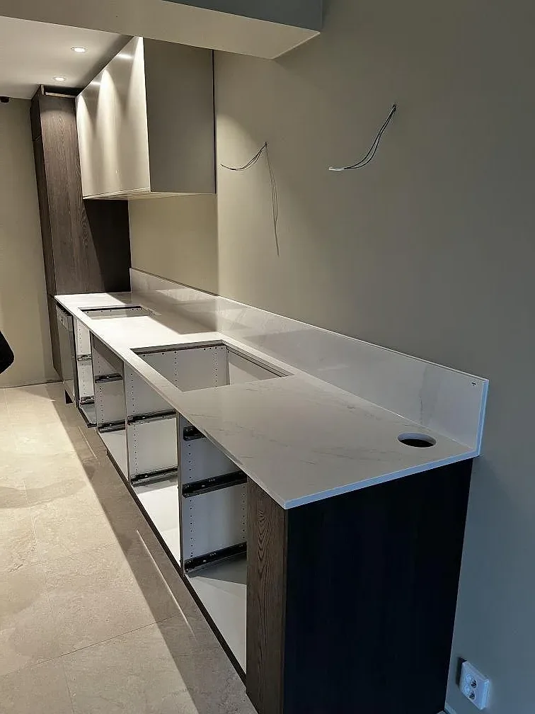 Köksbänkskiva i vit Silestone Eternal Calacatta Gold, polerad, under montering på öppna köksstommar i Malmö.