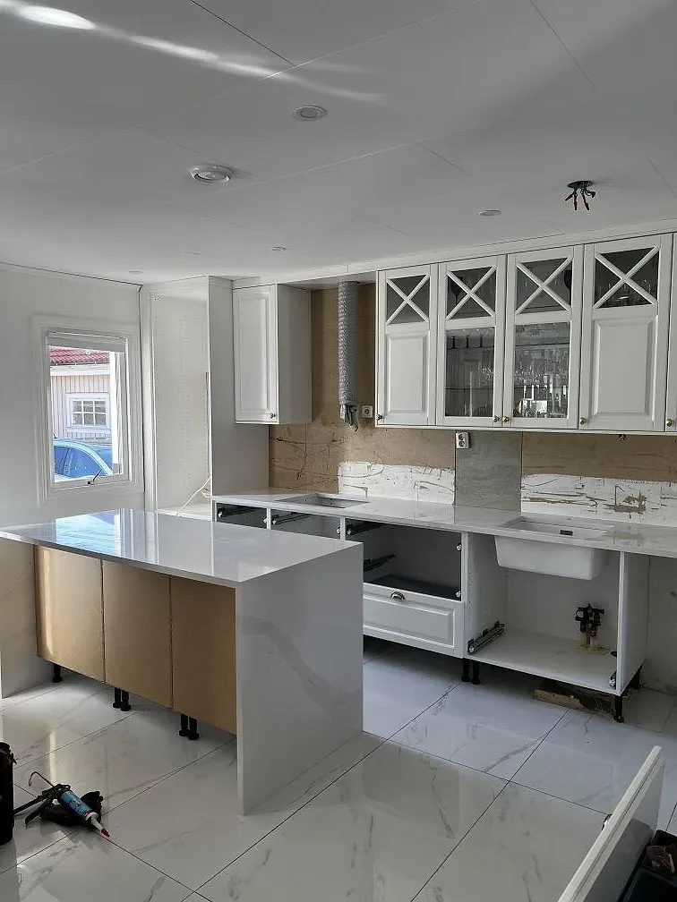 Köksinredning i Skövde med köksö och bänkskivor i polerad Silestone Eternal Calacatta Gold under montering.
