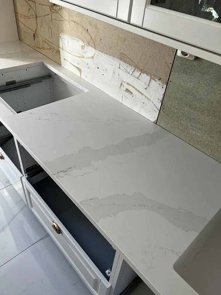 Bänkskiva i Silestone Eternal Calacatta Gold med markerad grå och guldfärgad ådring monterad ovanpå köksstommar i Skövde.
