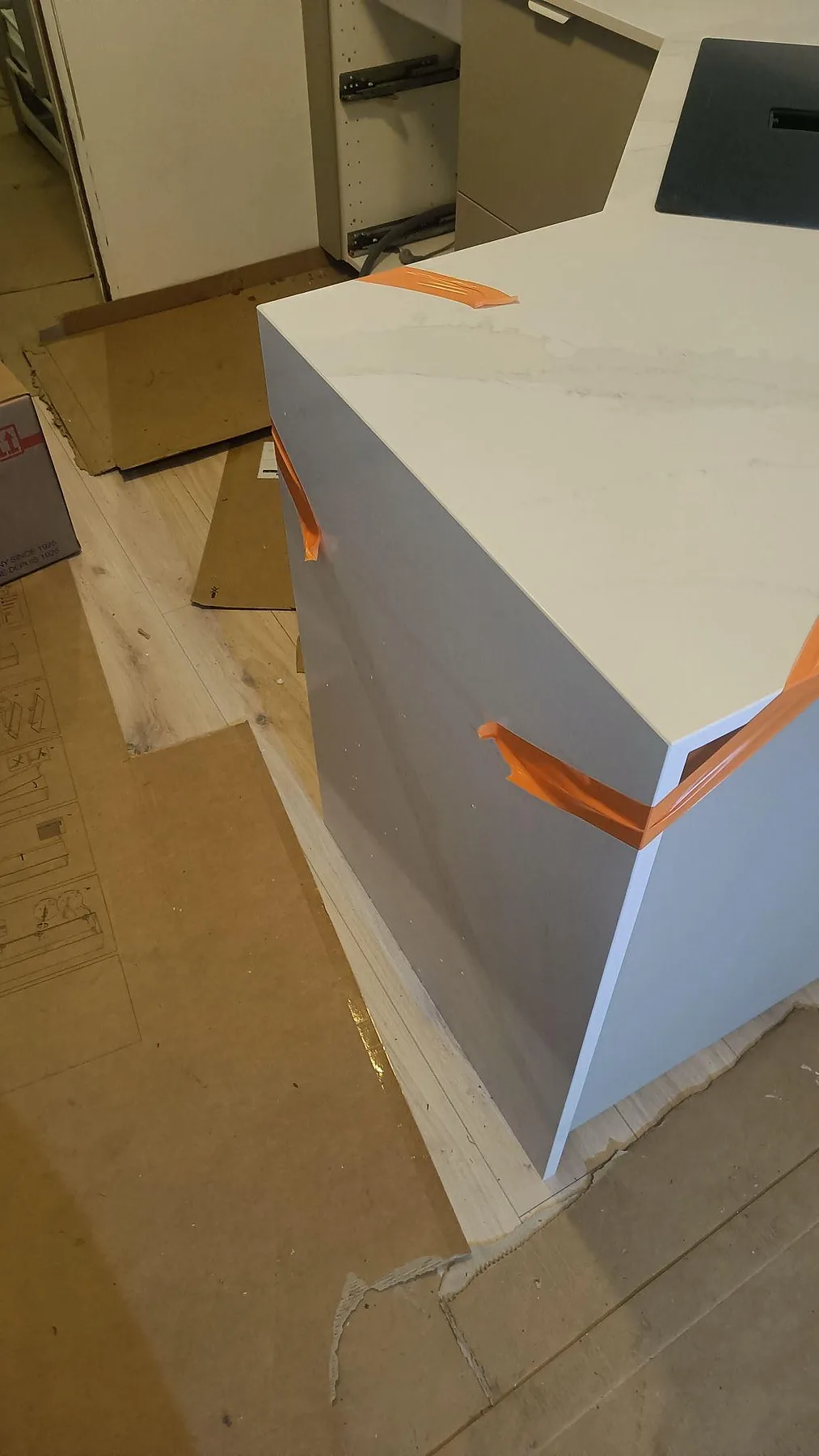 Detalj av tjock kant och polerad yta på köksö i Silestone Eternal Calacatta Gold under montering i Vellinge.