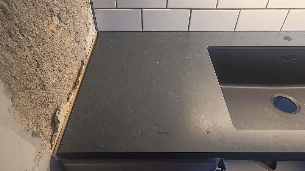 Sidovy av matt Silestone Eternal Charcoal Soapstone-bänkskiva med svart diskho och synlig charcoal-ådring i Göteborg.