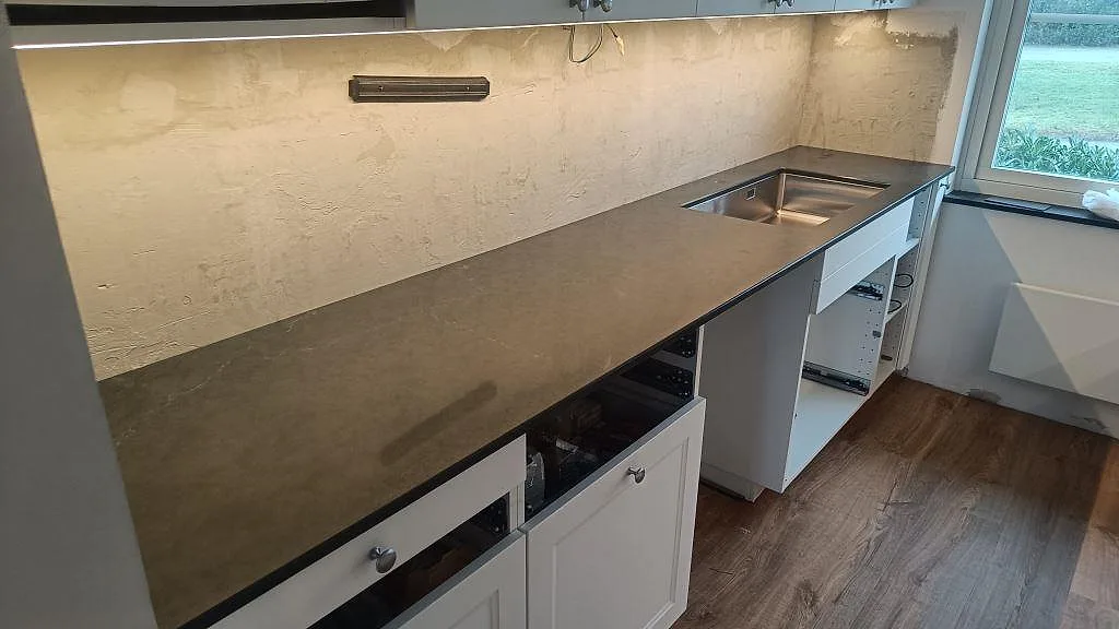 Lång köksbänkskiva i polerad Silestone Eternal Charcoal Soapstone med underlimmad rostfri diskho i Södra Sandby.