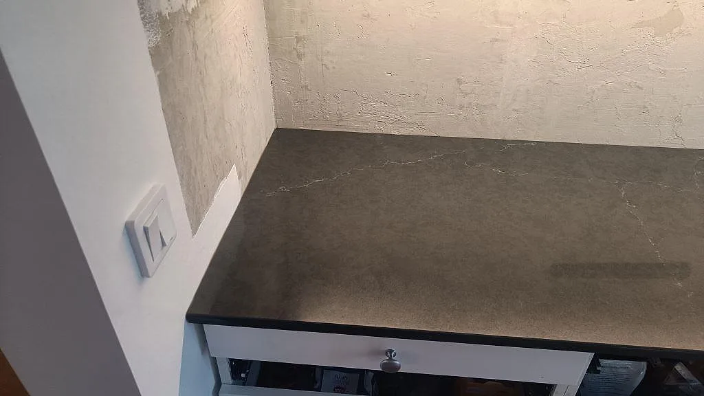Närbild på mörk polerad Silestone Eternal Charcoal Soapstone köksbänkskiva mot den ljusa väggen i Södra Sandby.