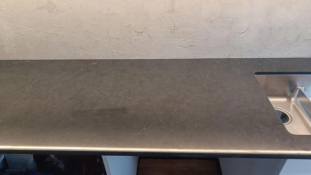 Detalj av polerad Silestone Eternal Charcoal Soapstone med subtil ljus ådring och rostfri diskho i Södra Sandby.