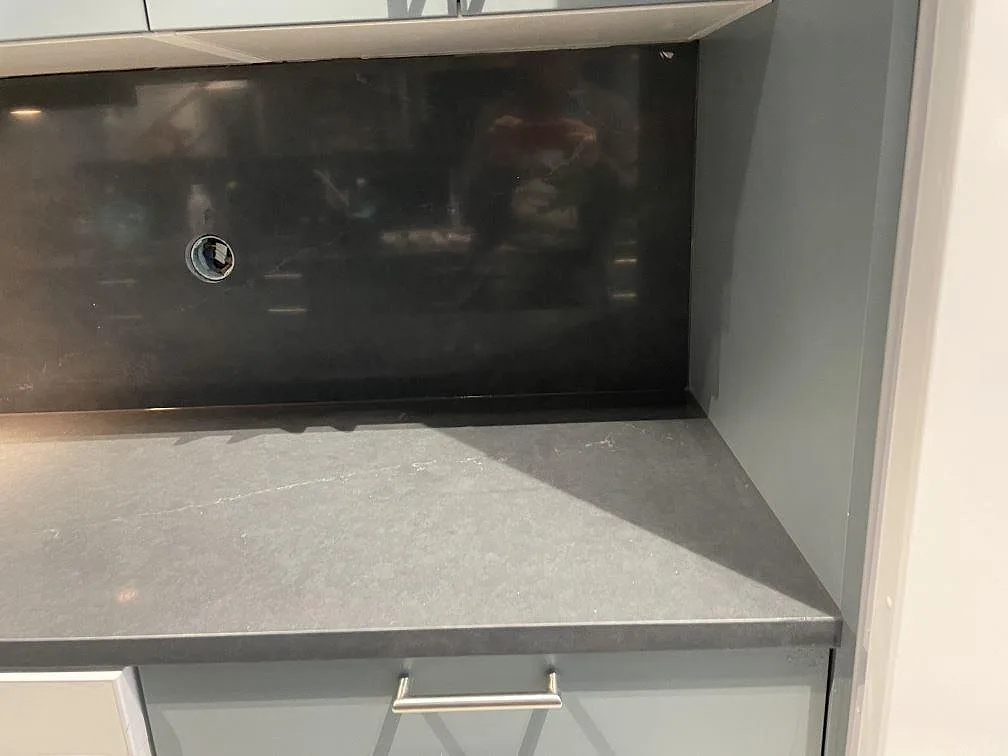 Detaljbild av mörk polerad Silestone Eternal Charcoal Soapstone som köksbänkskiva med stänkskydd och grå låda i Trollhättan.