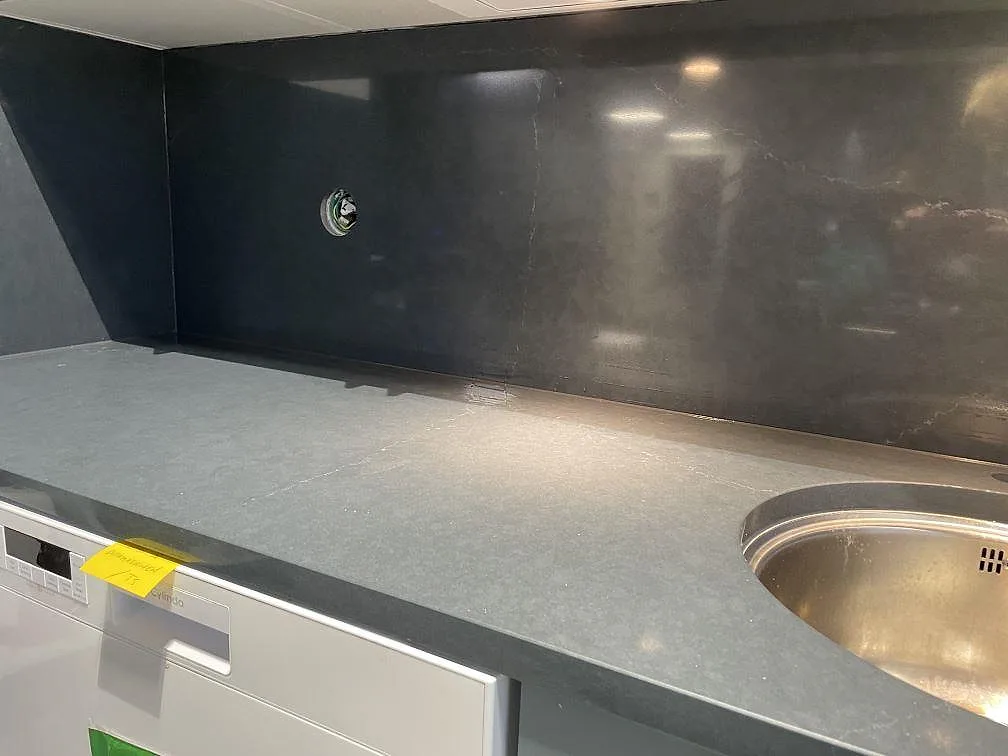 Lång köksbänkskiva i polerad Silestone Eternal Charcoal Soapstone med rund underlimmad rostfri diskho och mörkt stänkskydd i Trollhättan.