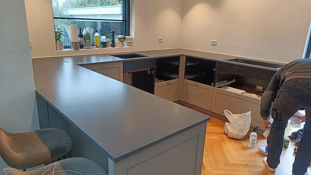 Köksbänkskiva i Silestone Eternal Charcoal Soapstone, 20 mm Mocka, monterad på grå köksstommar i ett kök i Vedbæk.