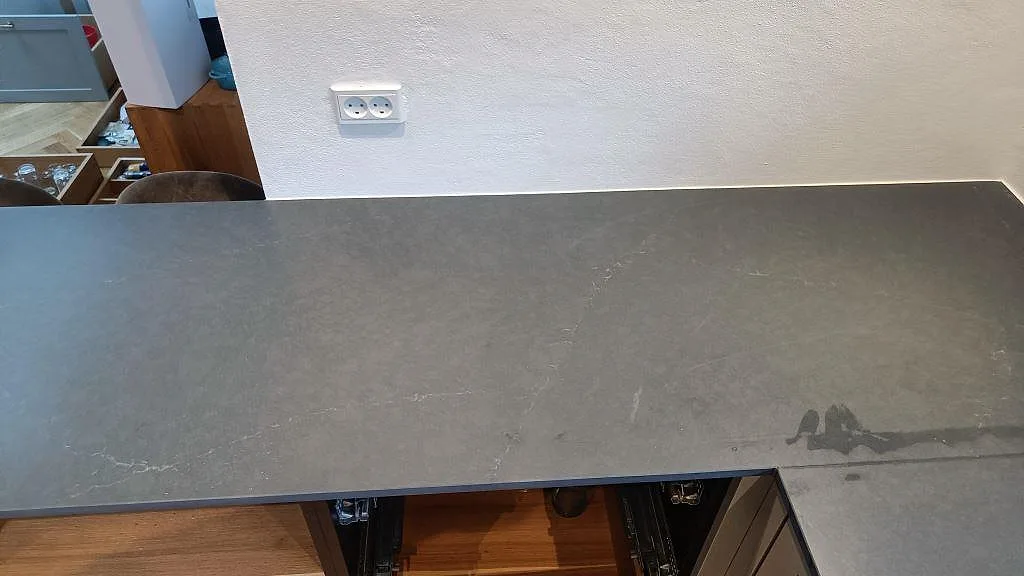 Topp av matt grå Silestone Eternal Charcoal Soapstone bänkskiva med diskret vit ådring i ett kök i Vedbæk.