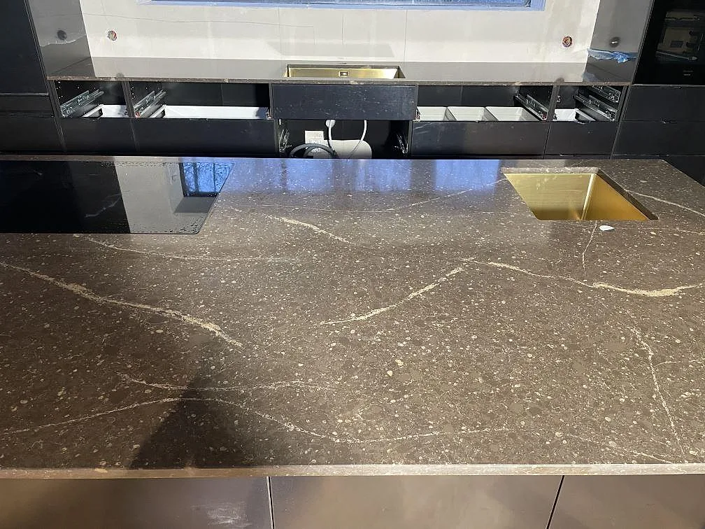 Infälld häll i polerad Silestone Eternal Emperador, mörkbrun kvartskomposit, monterad i köksön i Urshult.