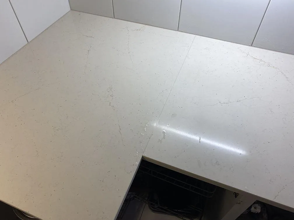 Närbild av skarv och ådring i polerad Silestone Eternal Marfil på köksbänkskiva i Lomma.