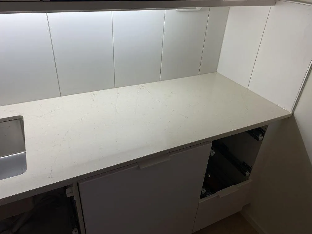 Rak bänkskiva i polerad Silestone Eternal Marfil med diskret ådring och ljus köksinredning i Lomma.