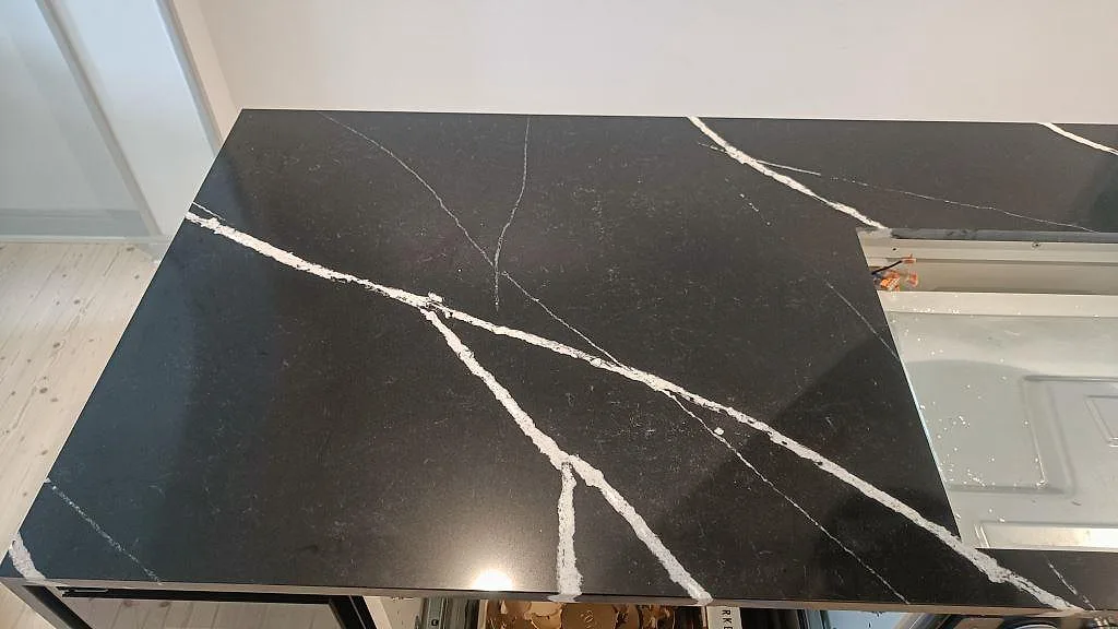 Närbild på den vita ådringen i den polerade svarta köksön i Silestone Eternal Marquina i Malmö.