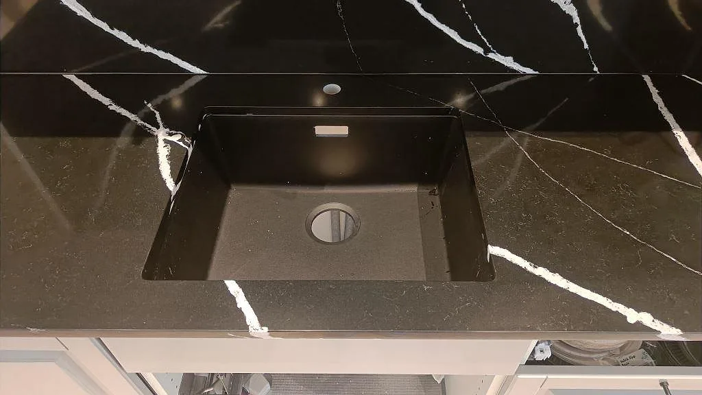 Underlimmad svart diskho i polerad Silestone Eternal Marquina med vit ådring i ett kök i Malmö.