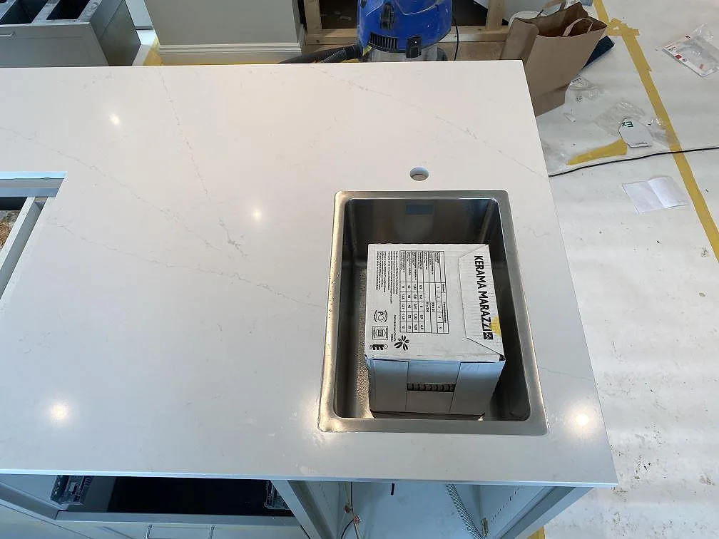 Köksö i polerad Silestone Eternal Statuario med underlimmad rostfri diskho ovanifrån i ett kök i Åryd.