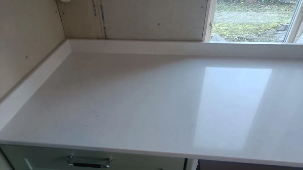Polerad bänkskiva i Silestone Eternal Statuario vid fönster, med ljus reflektion och diskret ådring i Alingsås.