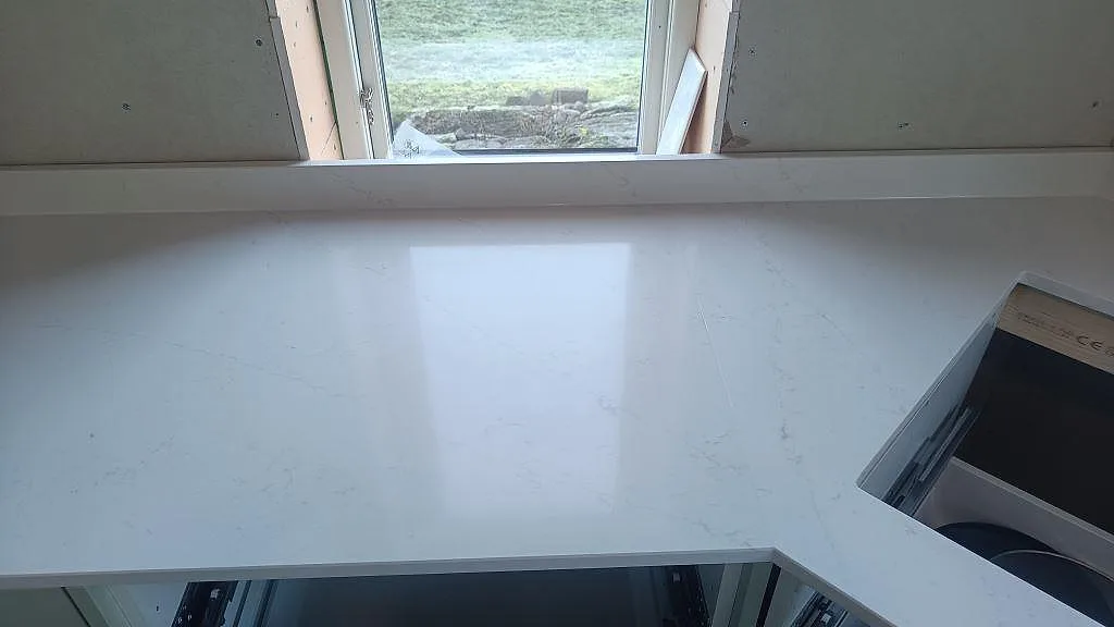 Köksbänkskiva i Silestone Eternal Statuario med hälluttag, stänkkant och fönsterljus i Alingsås.