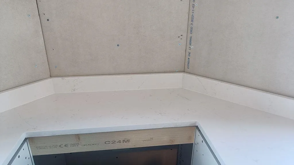 Närbild på hörn och stänkkant i polerad Silestone Eternal Statuario över hällöppning i Alingsås.