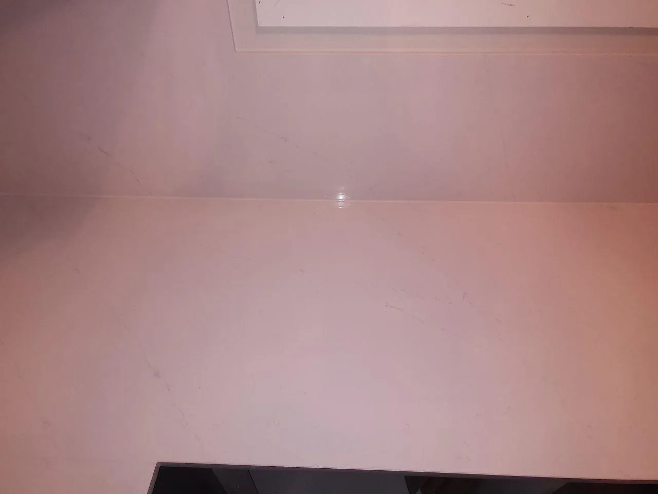 Närbild på den vita polerade ytan i Silestone Eternal Statuario med fin grå ådring, köksbänkskiva i Borås.