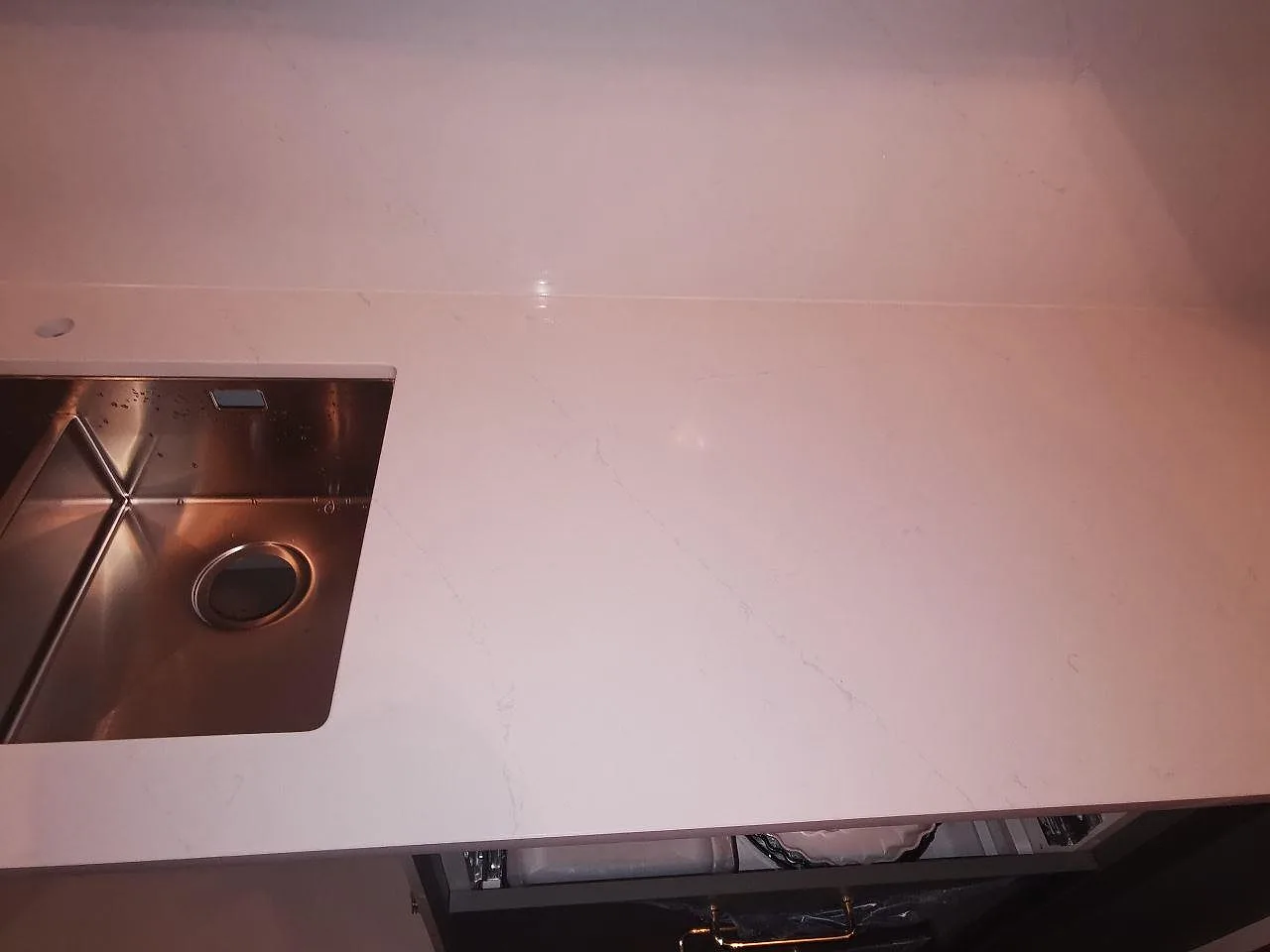 Polerad köksbänkskiva i Silestone Eternal Statuario sedd ovanifrån med kvadratisk underlimmad rostfri diskho, i ett kök i Borås.