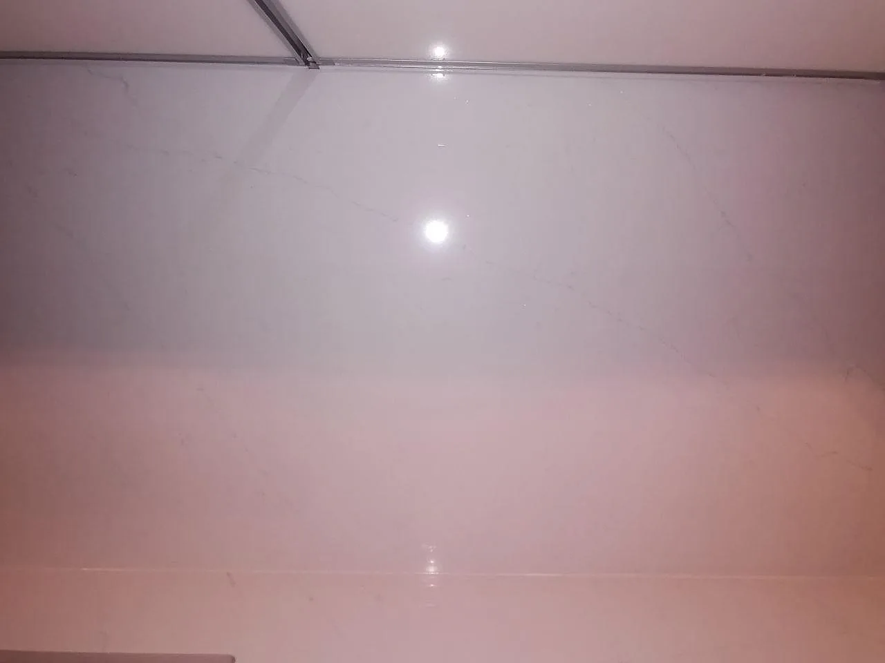 Nedåtbild på den polerade köksbänkskivan i Silestone Eternal Statuario med diskretgrå ådring i ett kök i Borås.