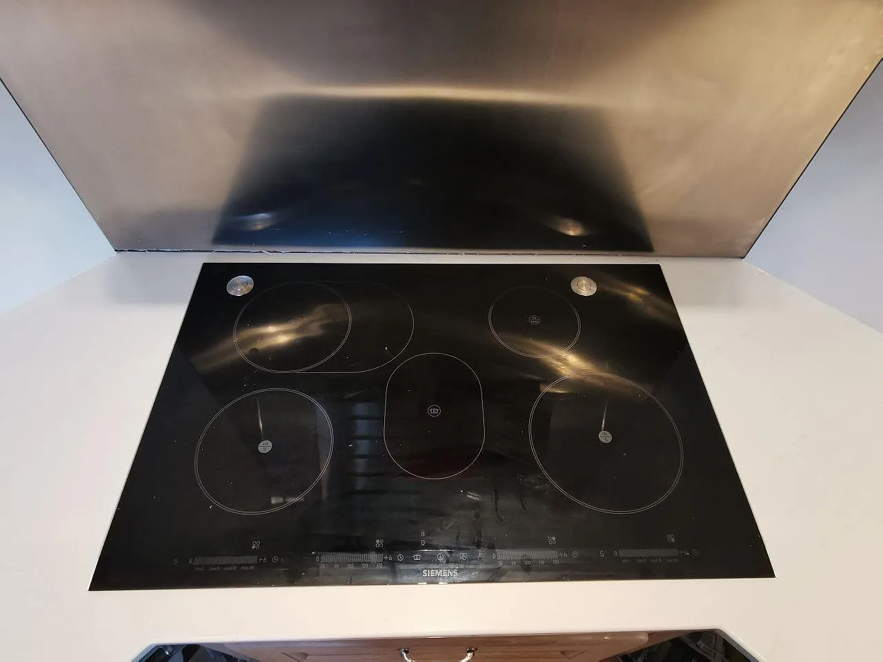Siemens induktionshäll övermonterad i en polerad Silestone Eternal Statuario köksbänkskiva i Borås.