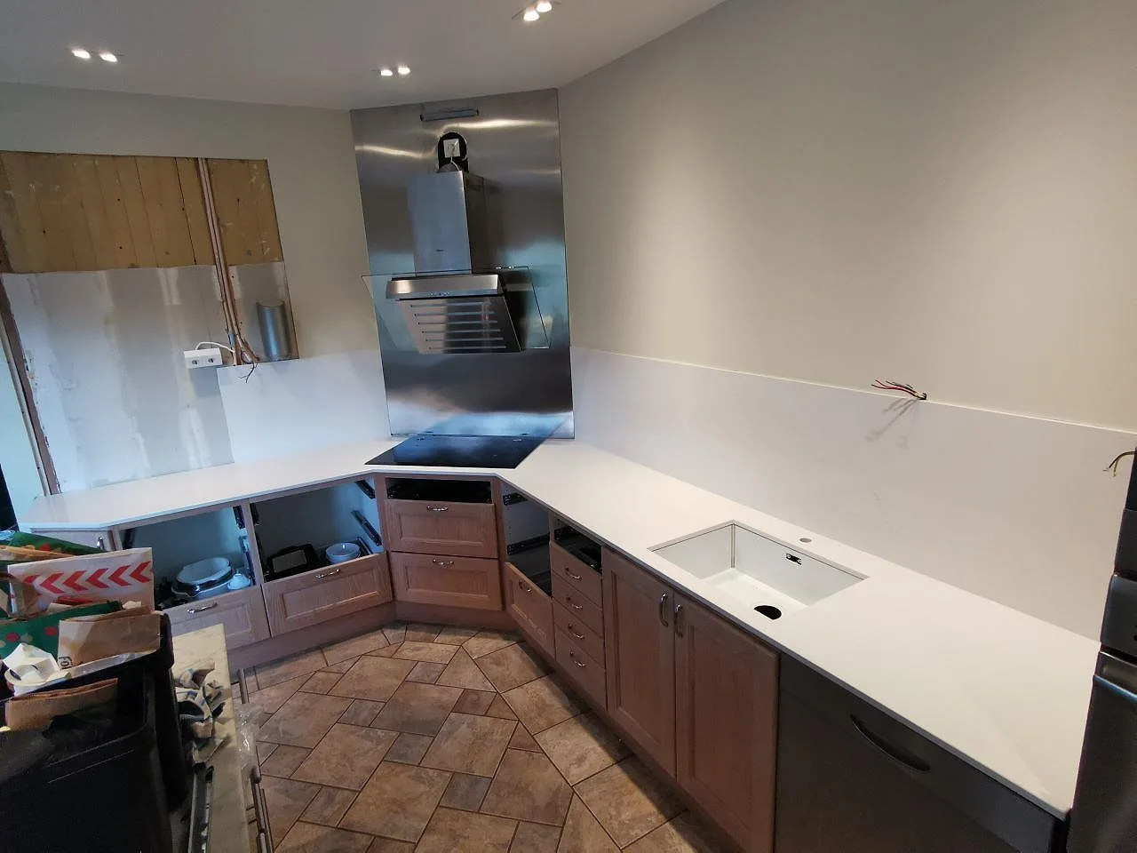 Köksbänkskiva i vit Silestone Eternal Statuario, polerad, i ett U-format kök i Borås med underlimmad rostfri diskho och induktionshäll under montering.