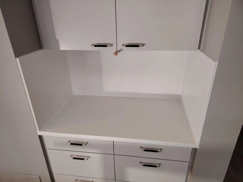 Polerad sidobänk i vit Silestone Eternal Statuario komposit med uppvikt stänkskydd och svag grå ådring i Frösunda.