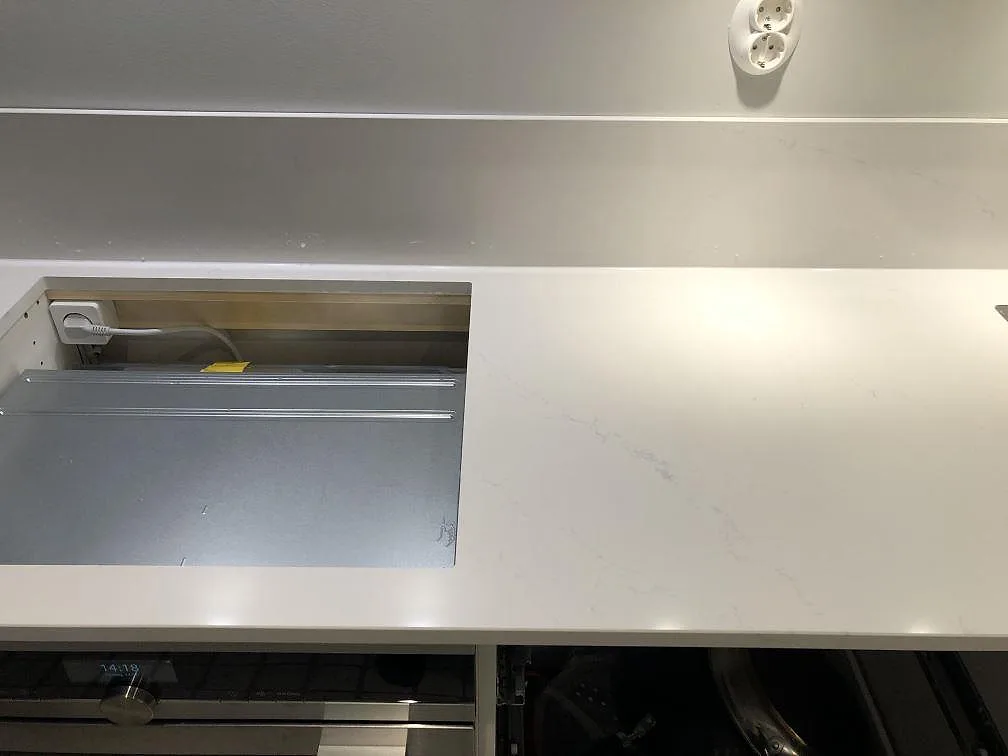 Köksbänkskiva i vit Silestone Eternal Statuario med urtagning för häll och synlig ådring i ett kök i Göteborg.