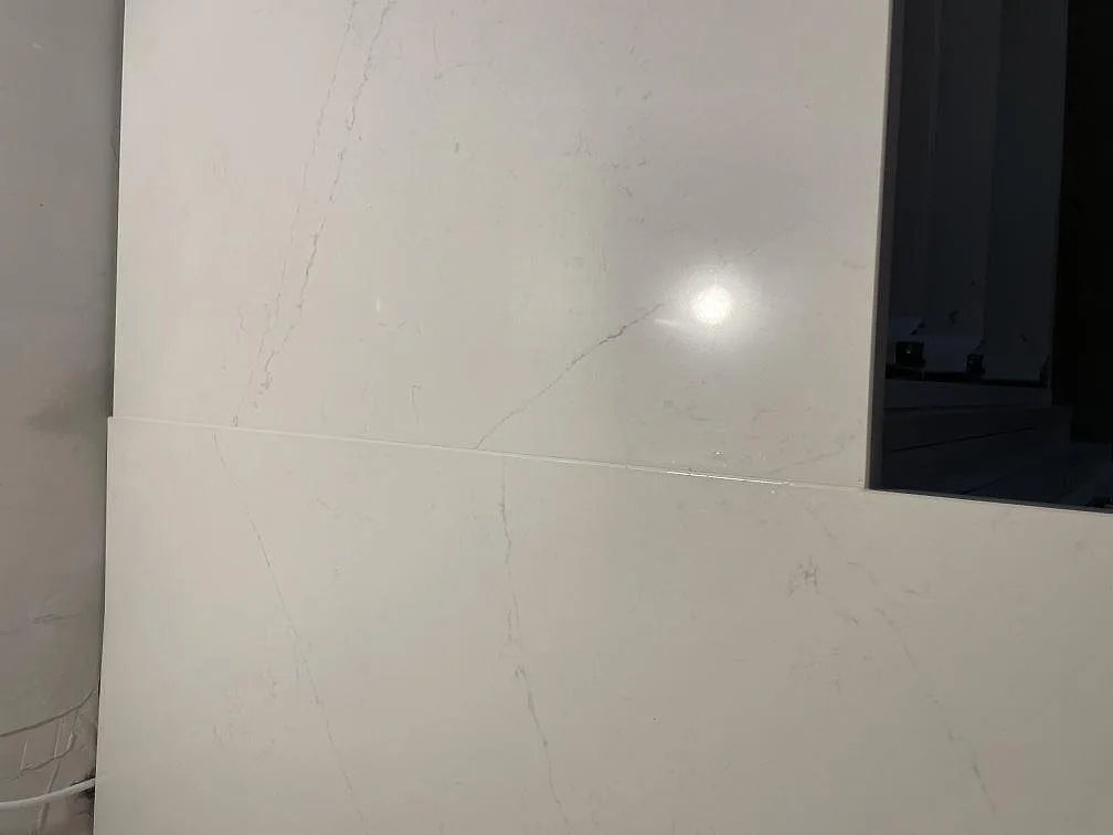 Närbild på den polerade ytan i Silestone Eternal Statuario med fin grå ådring och skarv på köksbänkskivan i Kävlinge.