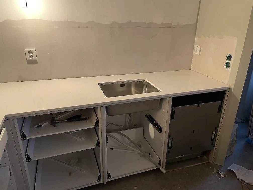 Polerad köksbänkskiva i Silestone Eternal Statuario med underlimmad rostfri diskho längs en vägg i ett kök i Kävlinge.