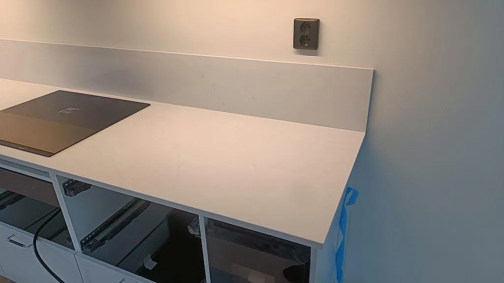 Topbild av polerad Silestone Eternal Statuario köksbänkskiva med grå ådring i Karlshamn.