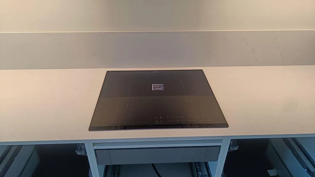 Infälld induktionshäll i vit polerad Silestone Eternal Statuario köksbänkskiva i Karlshamn.