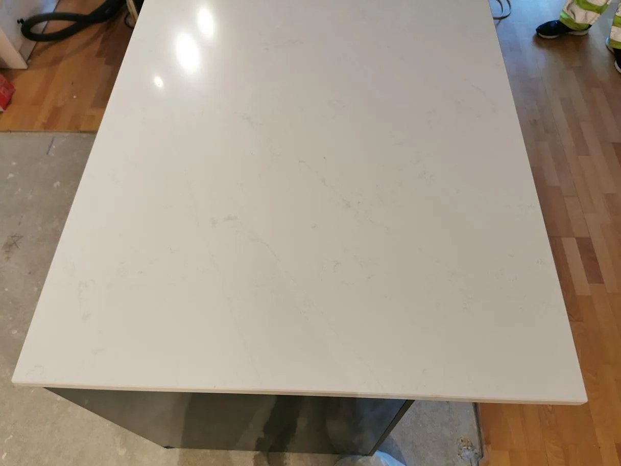 Polerad yta i Silestone Eternal Statuario som speglar kökets belysning i ett kök i Kristianstad.