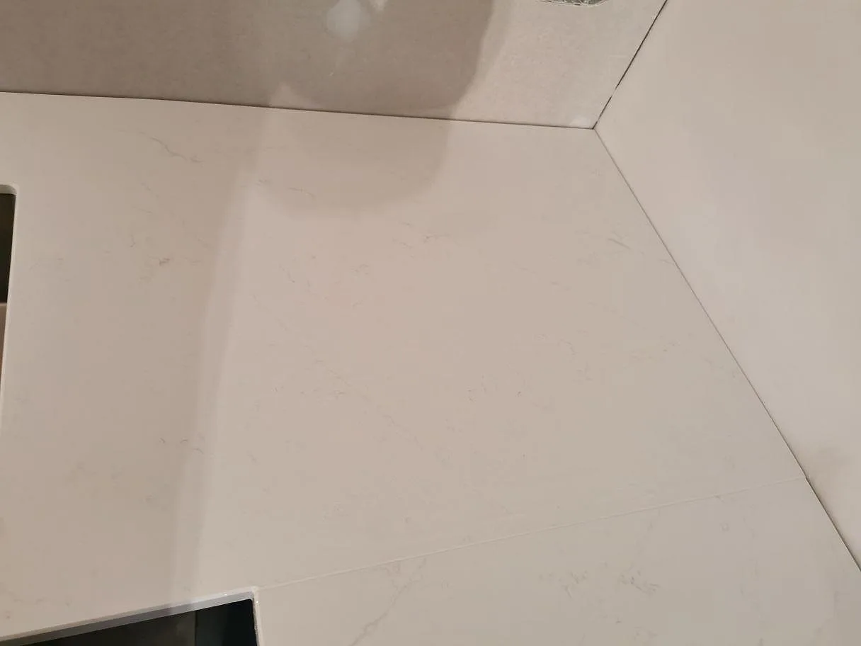Skärning och skarv i polerad vit Silestone Eternal Statuario bänkskiva i ett kök i Kristianstad.