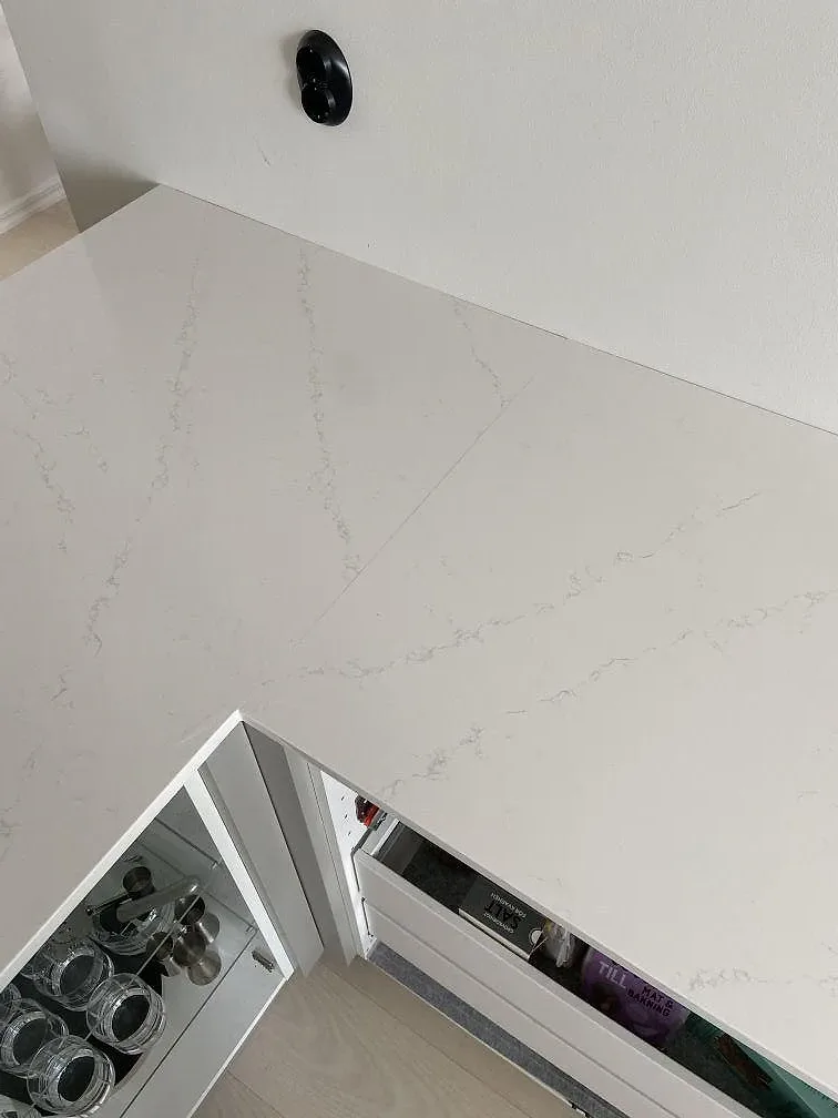 Närbild på den grå ådringen i polerad Silestone Eternal Statuario, en vit kvartskomposit, i ett kök i Kungsbacka.
