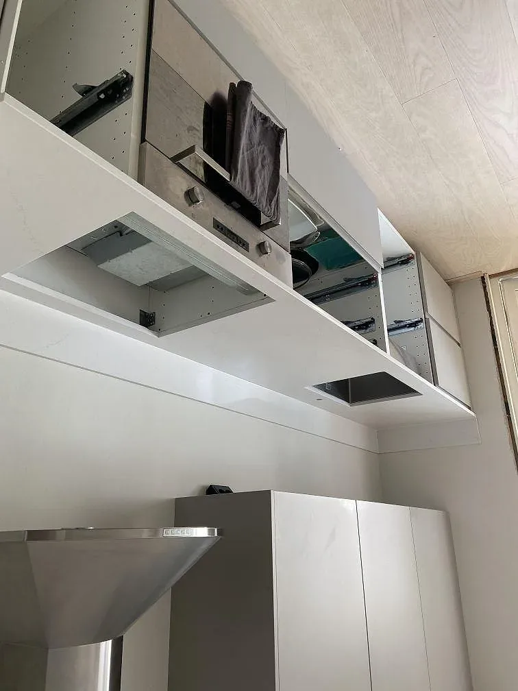 Polerad köksbänk i Silestone Eternal Statuario med rostfri köksfläkt över bänken i ett kök under montering i Kungsbacka.